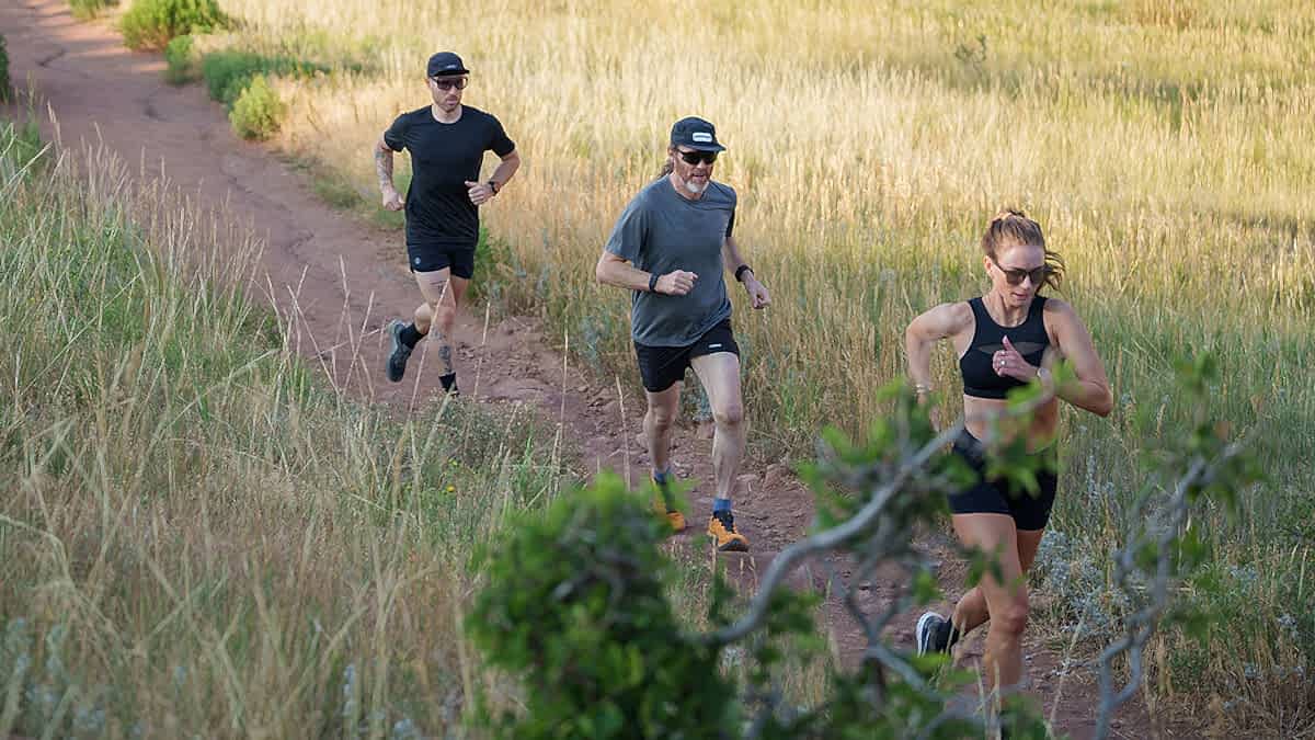 Three Runners On A Dirt Trail On A Sunny Day