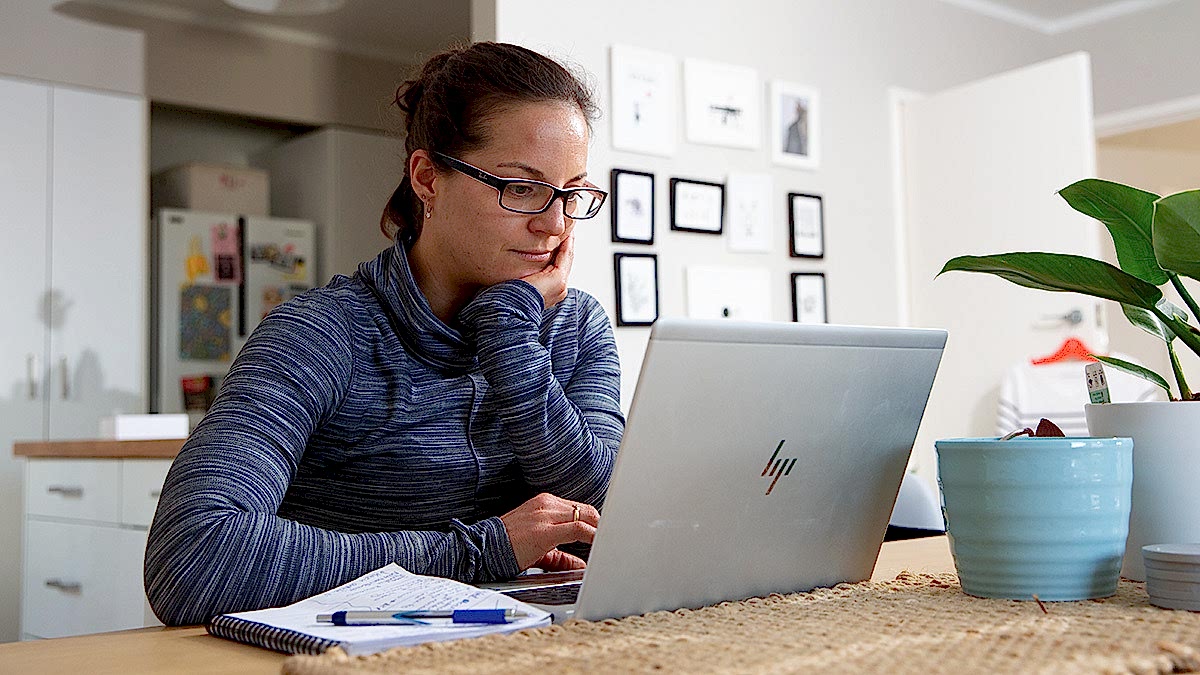 Triathlon Coach Woman Sitting At A Desk On A Computer Making Training Plans For Athletes